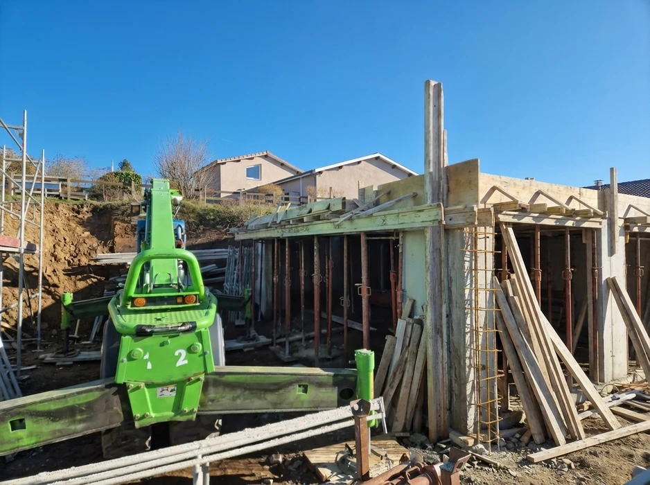 Chantier de construction urbain en extérieur avec ouvriers équipés de casques de sécurité travaillant sur une structure en béton armé