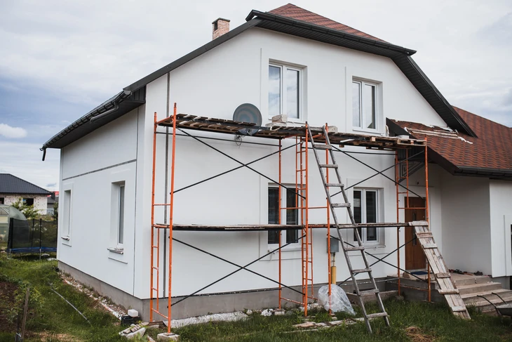 Façade résidentielle avec architecture mixte pierre naturelle et crépi beige