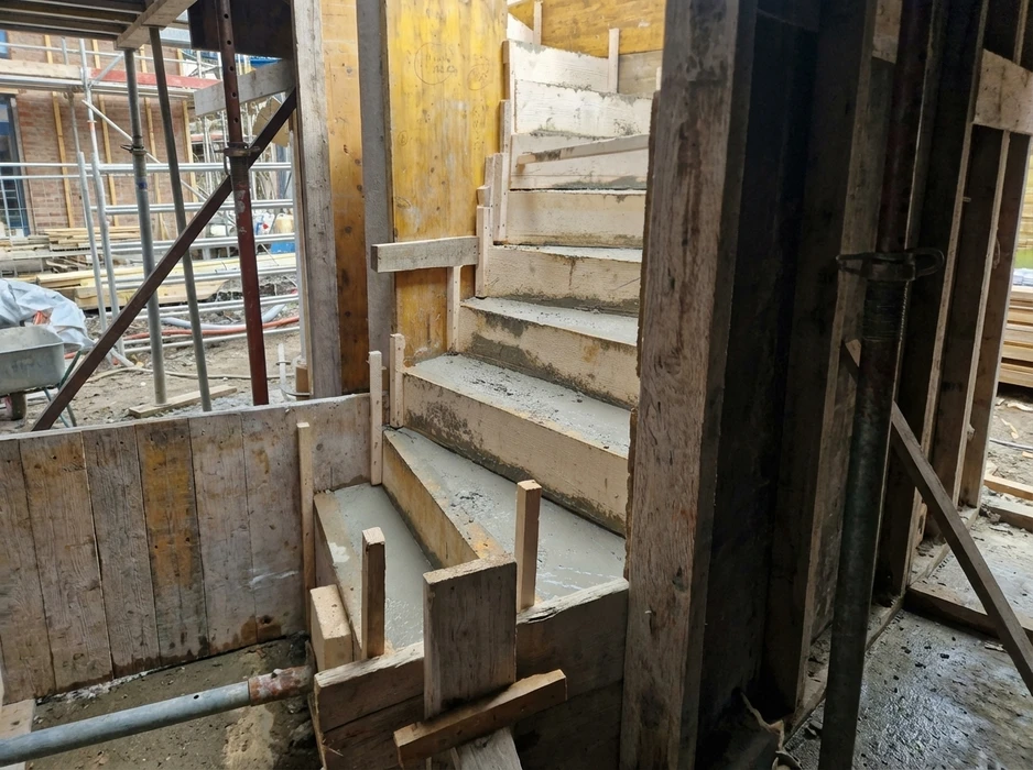 Chantier de couverture en cours, vue extérieure d'une toiture en pente avec ouvrier installant des tuiles terre cuite